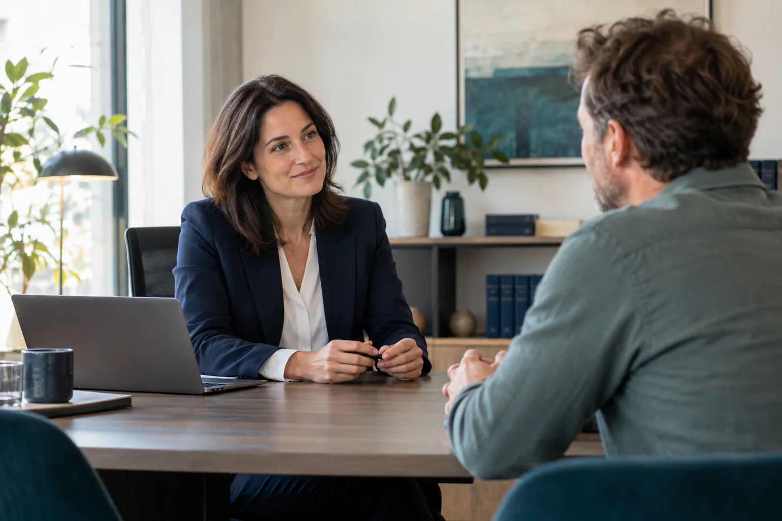Avocate recevant un client dans un cabinet moderne pour illustrer la confiance et la qualité du premier échange.
